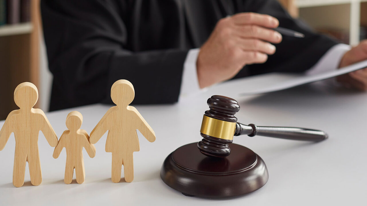 wooden figures next to a judge gavel and with a judge in the background