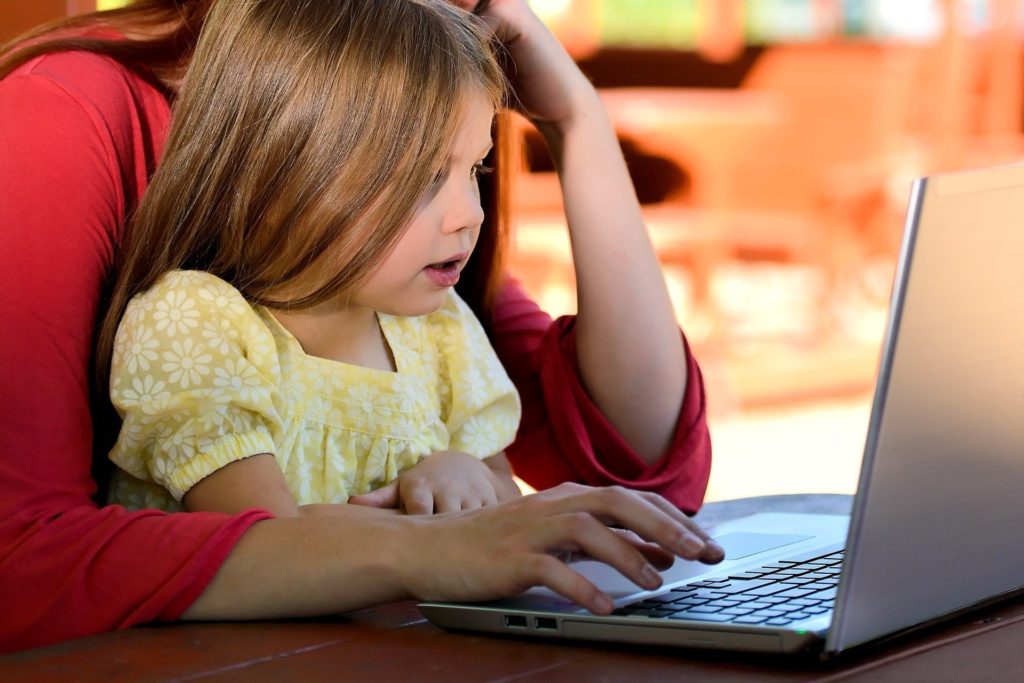 Woman with her daughter looking at computer