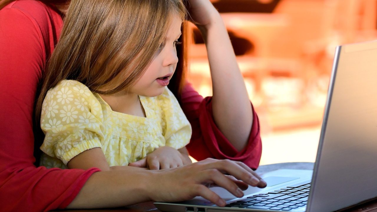 Woman with her daughter looking at computer