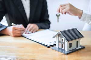 Woman handing over keys to house