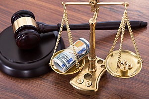 a judge gavel with a balance scale on a desk