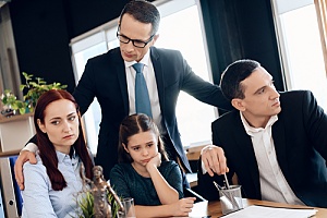 a lawyer comforting a couple deciding on custody agreements