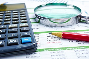 a spreadsheet of banking information a pencil and a calculator on a desk