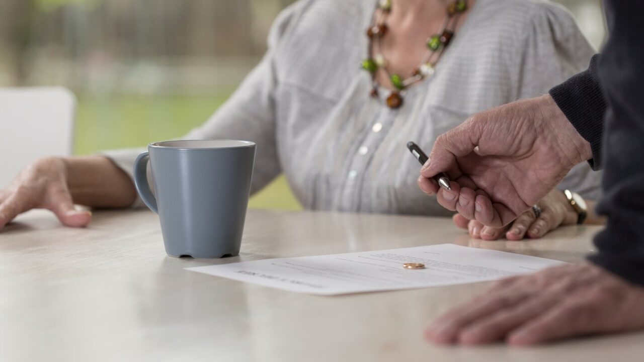 close up of elder man signing divorce documents