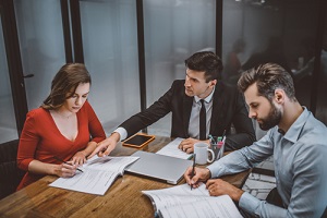 lawyer helping a couple to fill legal papers