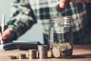 man putting coin in glass bottle saving bank and account for his money all in finance accounting