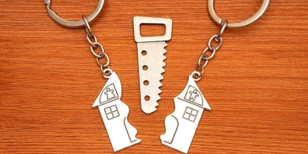 split house matching keychains with a small steel saw on a wooden table