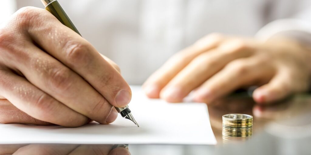 closeup of a man signing divorce papers