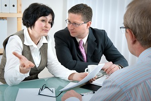 woman and her lawyer in conversation with husband during divorce process