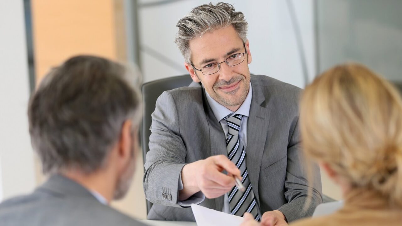 mature couple signing contract in lawyer's office