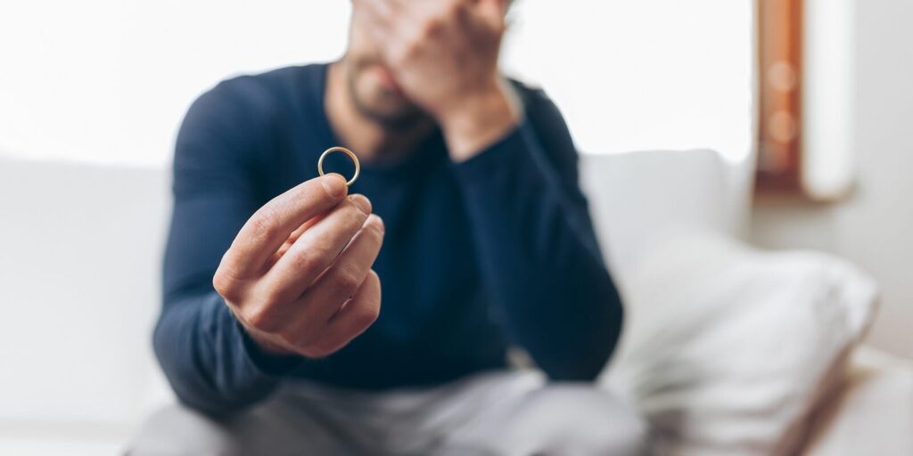upset man with engagement ring in hand