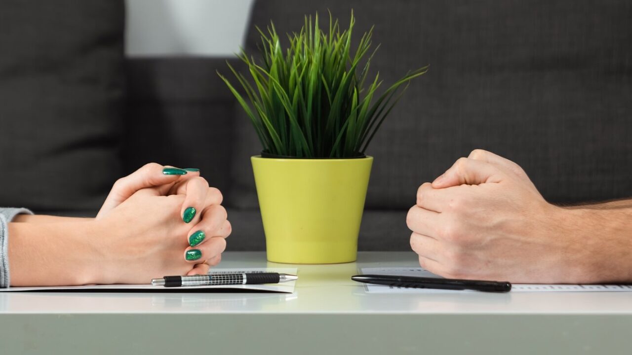 male and female hands are folded opposite each other