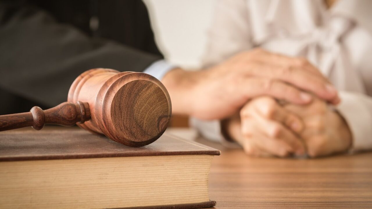 law books with attorney or lawyer provide legal advice and consoling to his clients in background