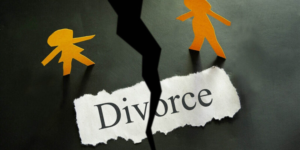 torn piece of paper with divorce text and paper couple figures