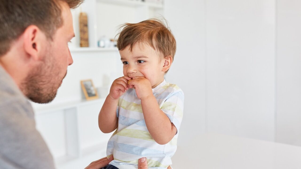 father takes care of his son with biscuit