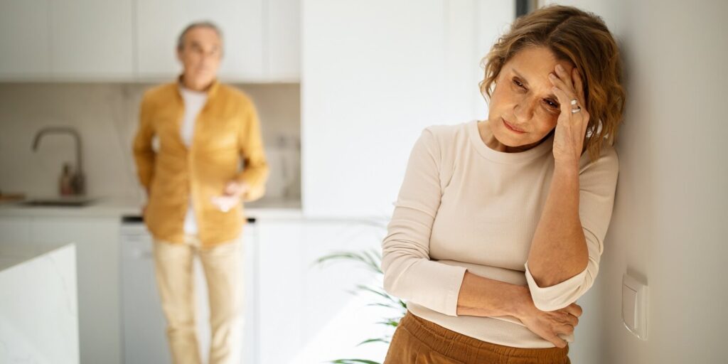 elderly caucasian couple standing in kitchen after argue