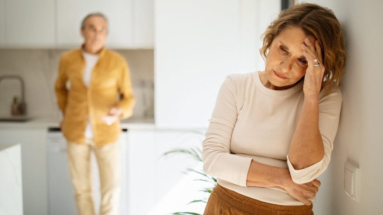 elderly caucasian couple standing in kitchen after argue