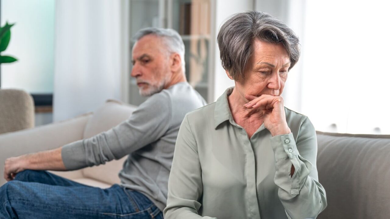 senior couple sitting on couch and ignoring each other