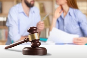 couple arguing in blurred background with court gavel