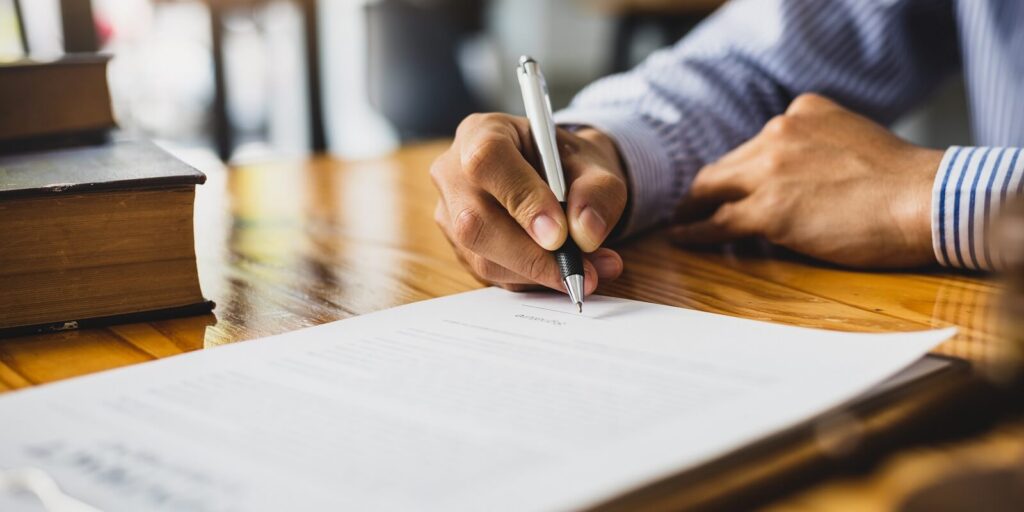 lawyer working in a law office reading agreement contract documents and signing