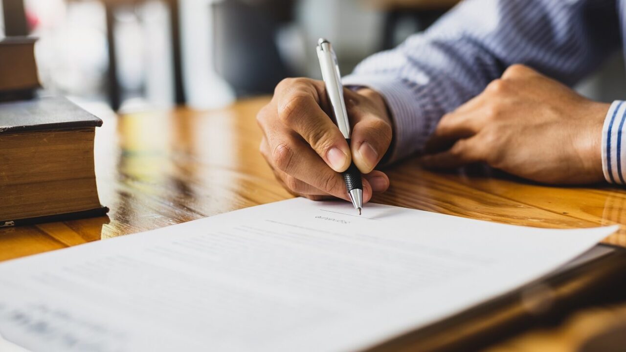 lawyer working in a law office reading agreement contract documents and signing