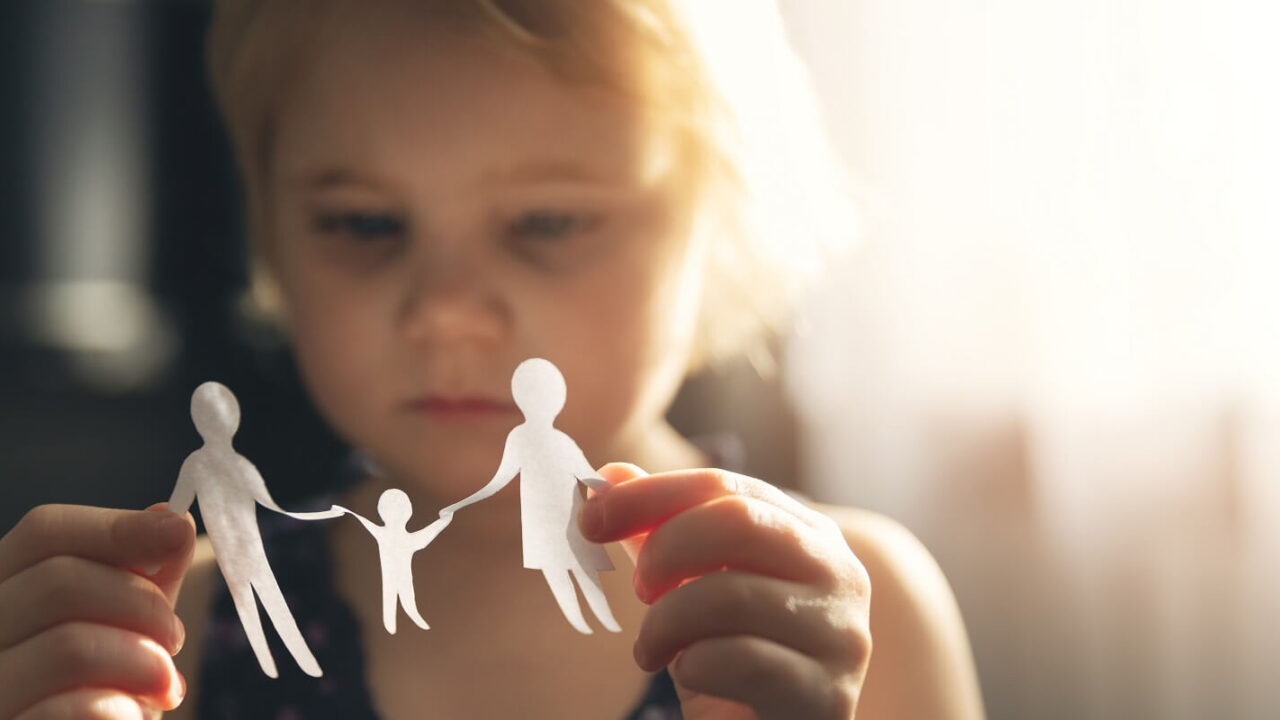 little girl with paper family in hands