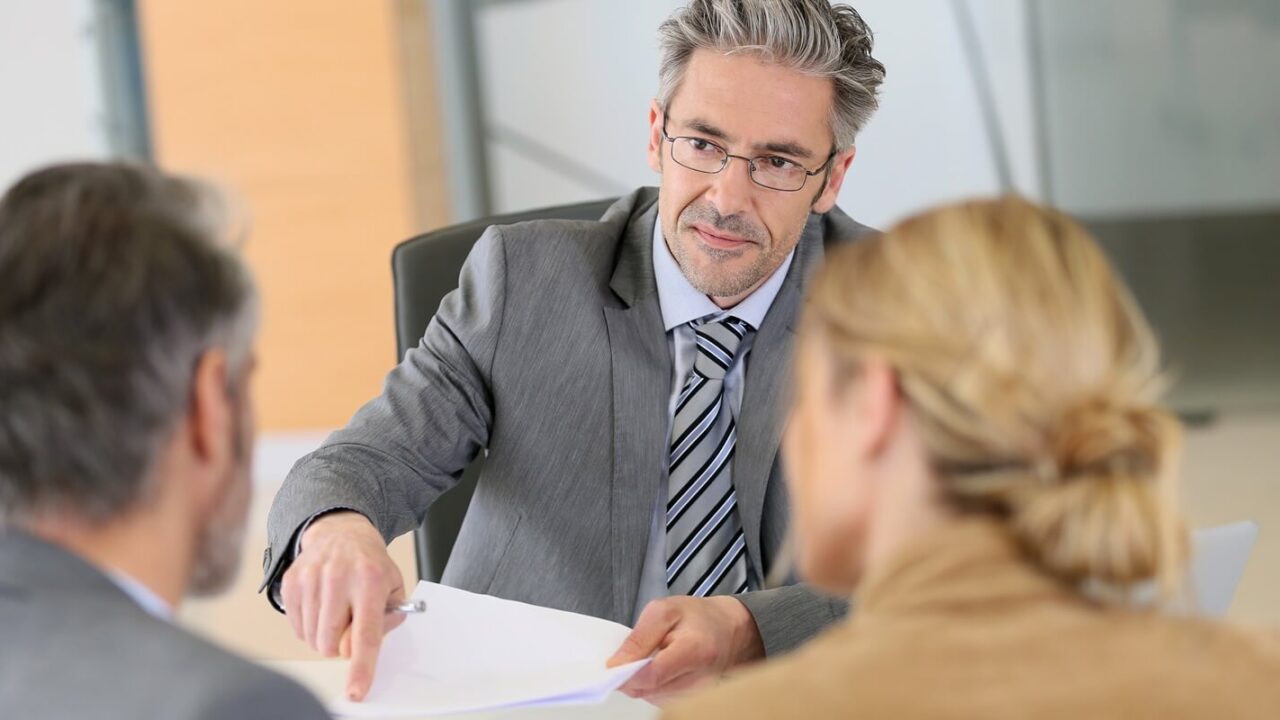 mature couple signing contract in lawyer's office