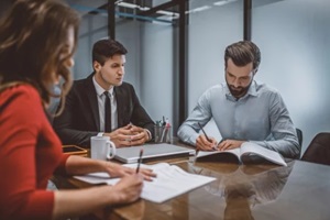 spouses writing a divorce request with their lawyer