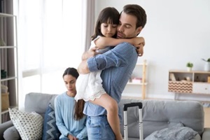 sad little girl upset by father leaving embracing dad