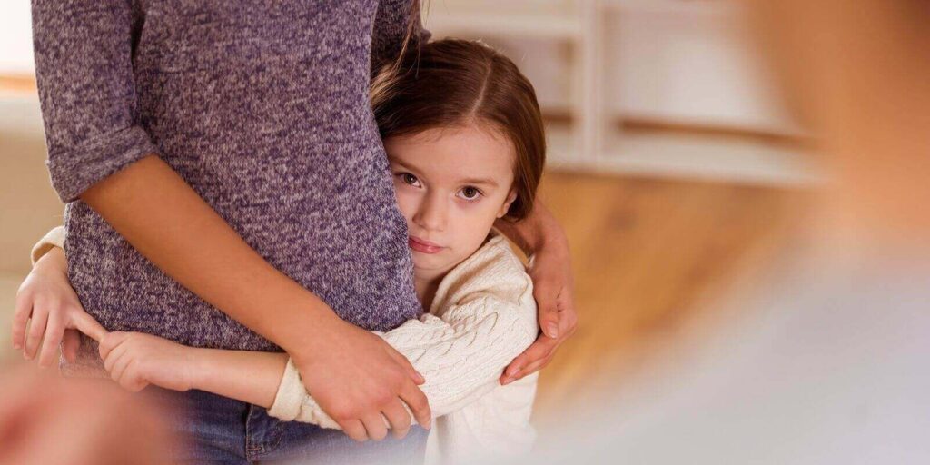 worried child hugging mom during quarrels between parents