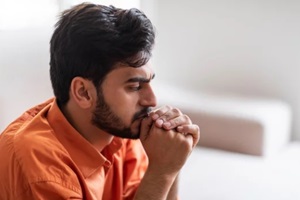 frustrated arab guy sitting on sofa at home, closeup