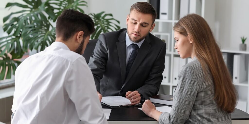 unhappy young couple visiting divorce lawyer in office