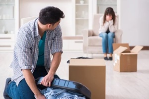 woman evicting man from house during family conflict