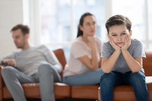 upset child boy looking at camera sad about parents fights