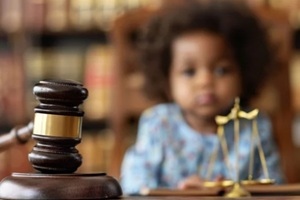 close up of a legal judges hammer with a blurred child in the background