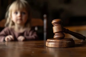 close up of a legal judges hammer with a blurred child in the background