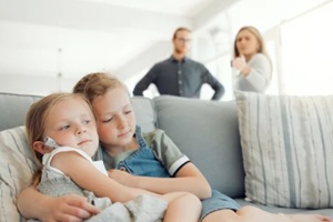 parents fight and girls comfort on sofa with hug from divorce