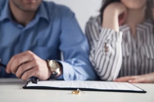 couple with divorce contract and ring on desk