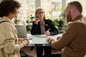 back view portrait of adult couple consulting attorney in office settling legal matters in marriage