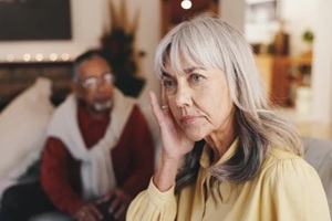 senior woman, stress and conflict with man on sofa in home with anger, ignore and retirement in lounge