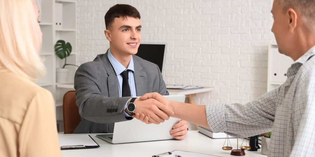 male lawyer with mature couple shaking hands with Maryland divorce attorney