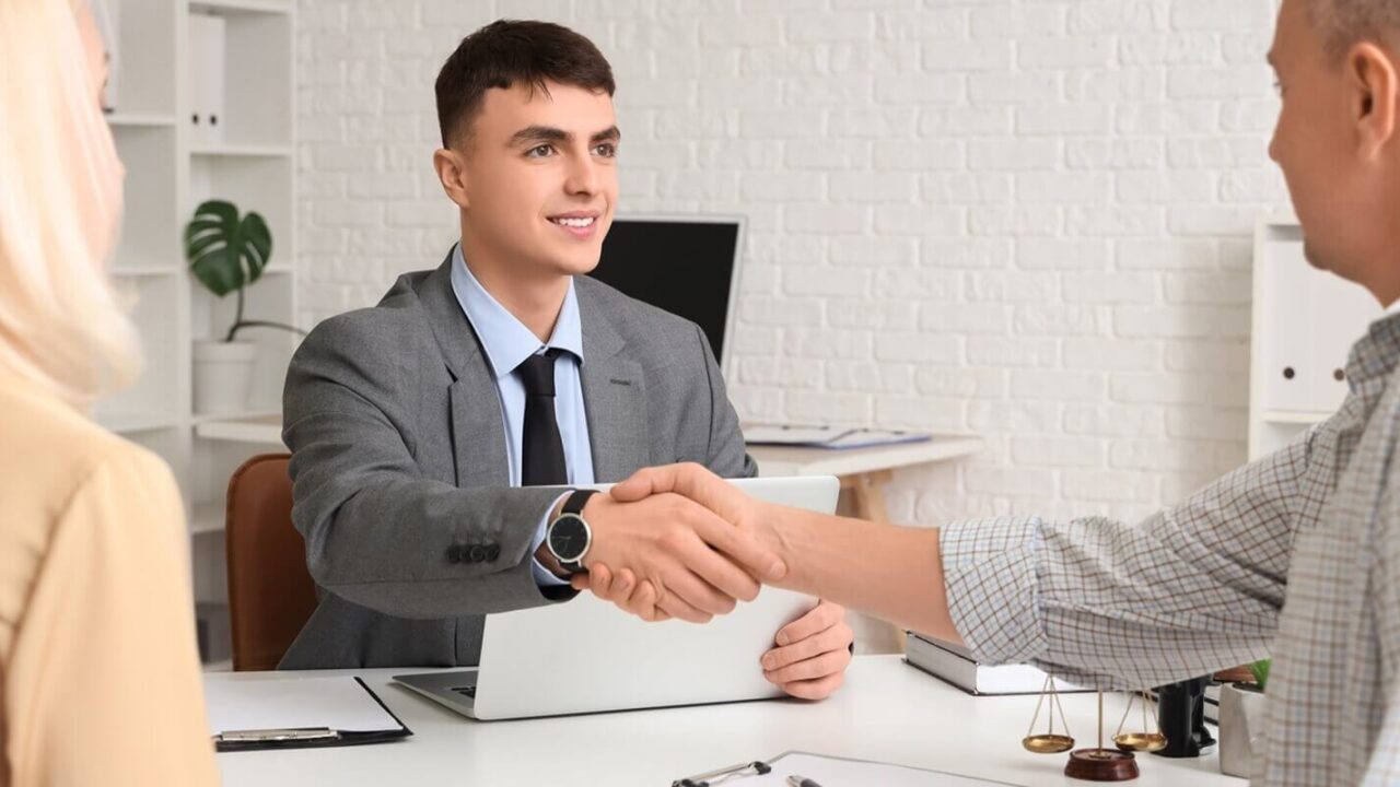 male lawyer with mature couple shaking hands with Maryland divorce attorney
