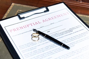 close-up of a prenuptial agreement form with wedding rings and a fountain pen