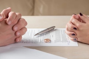Maryland wife and husband signing divorce documents or premarital agreement