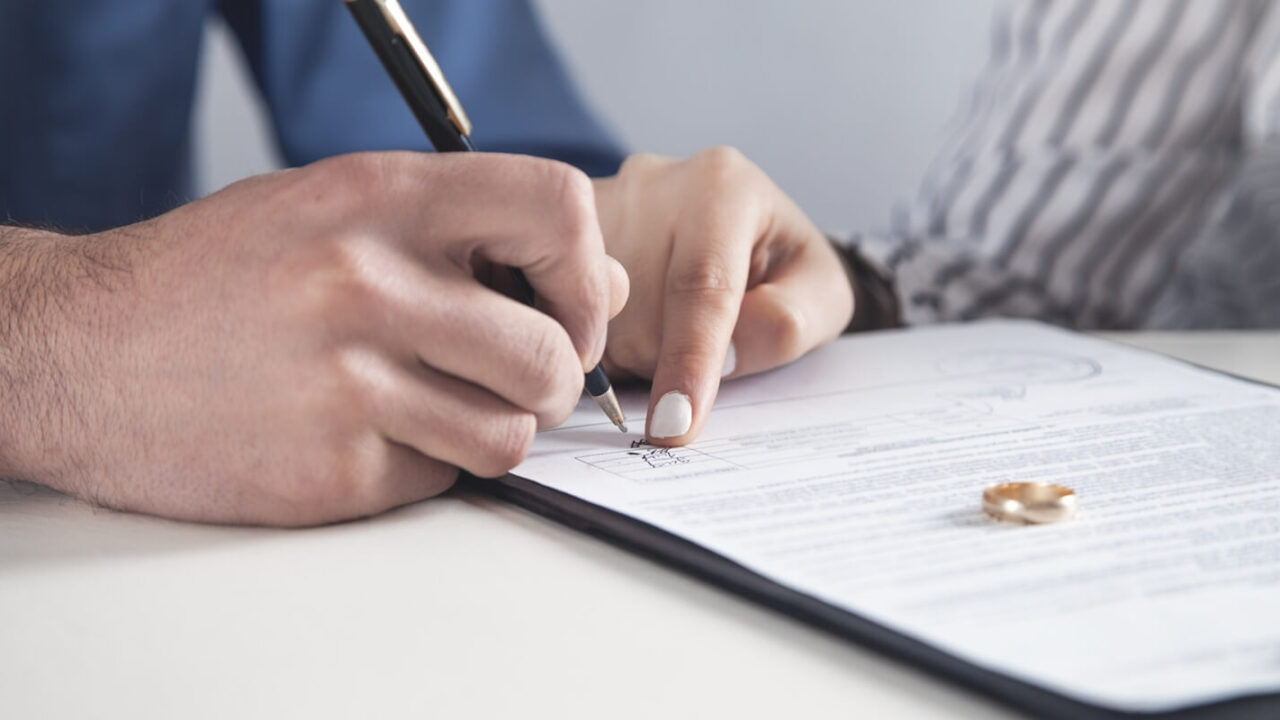 couple with divorce contract and ring on desk