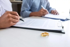 couple in the courthouse filing pen to signing divorce papers or premarital agreement, deciding on marriage divorce concept