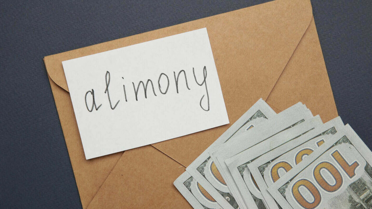 envelope with word alimony and money on dark blue background