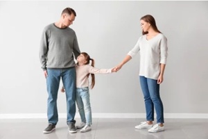 unhappy family after divorce against light wall