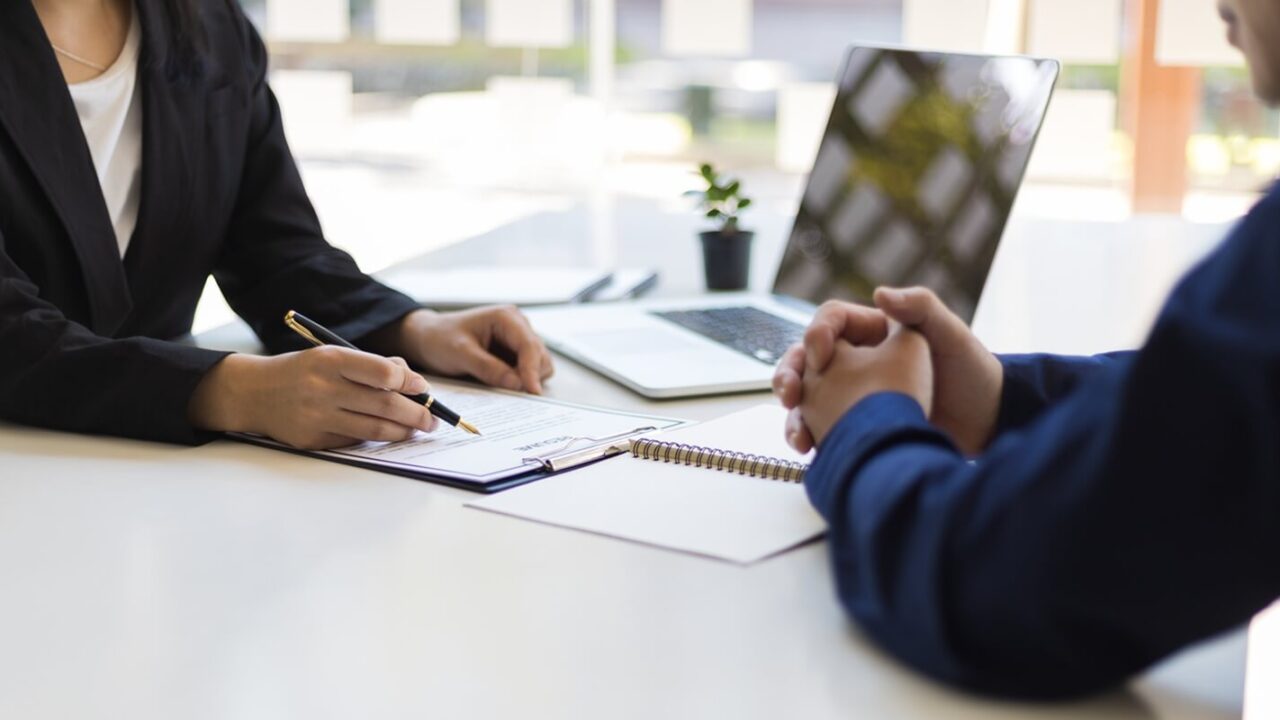 manager is reading the resume and is interviewing the new employee