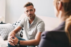 photo of confident focused man having conversation with psychologist in room